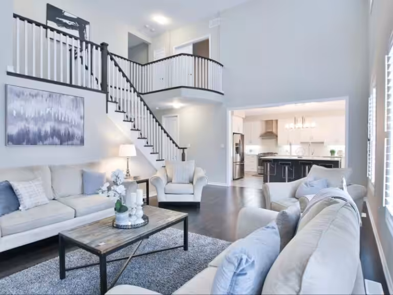 Open-concept living room and kitchen with recessed and pendant lighting after upgrade in the NH Seacoast.