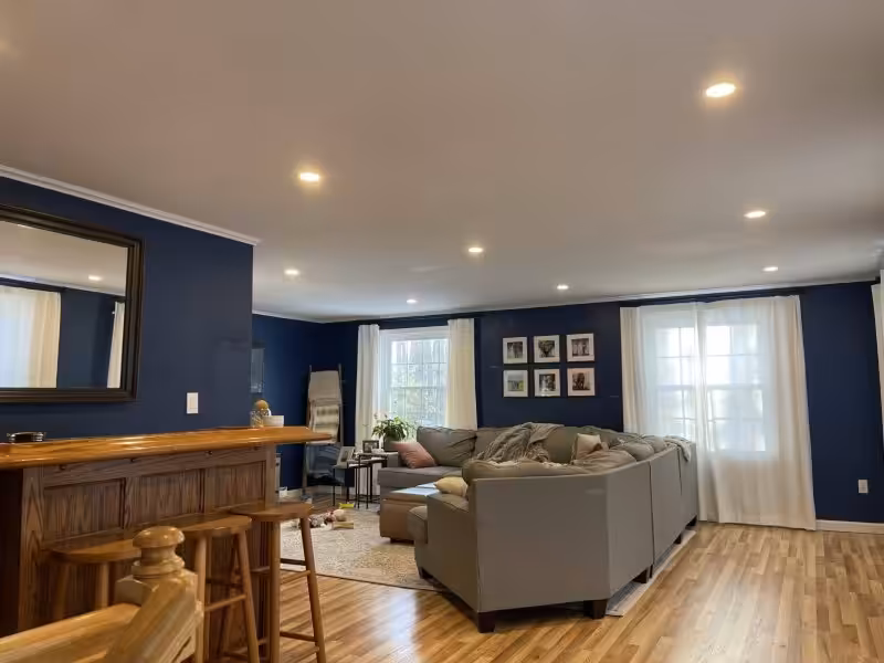 Living room with recessed LED ceiling lights after a lighting upgrade by Loyal Lab Electric & Generators in Dover, NH.