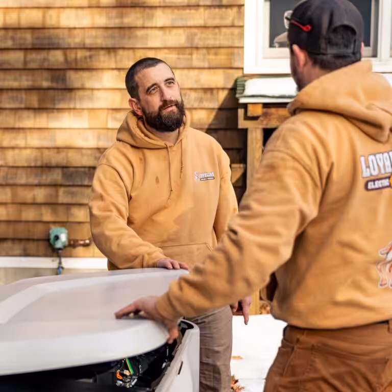 Loyal Lab Electric team members installing a generator at a Dover NH home