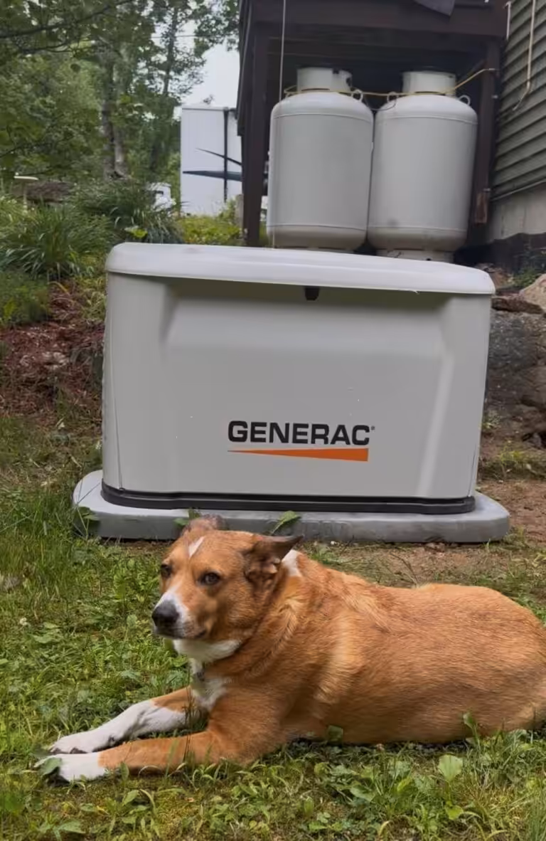 Next gen Generac standby generator installed by Loyal Lab Electric at a home in Ossipee NH with the customer's dog lying in front.